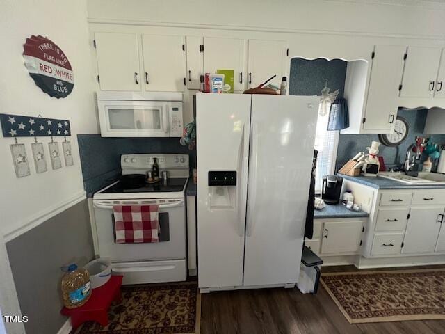 kitchen featuring dark wood-type flooring, white appliances, white cabinetry, and sink