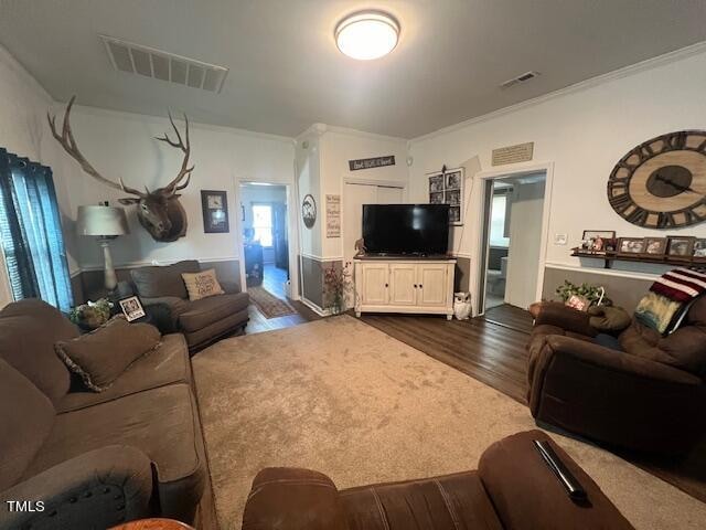 living room with dark wood-type flooring and crown molding