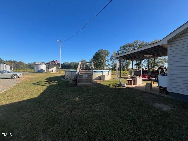 view of yard with a storage unit, a patio, and a pool