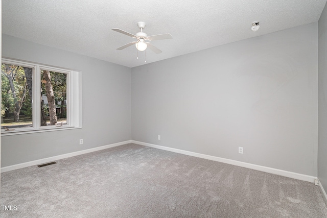 carpeted empty room with ceiling fan and a textured ceiling