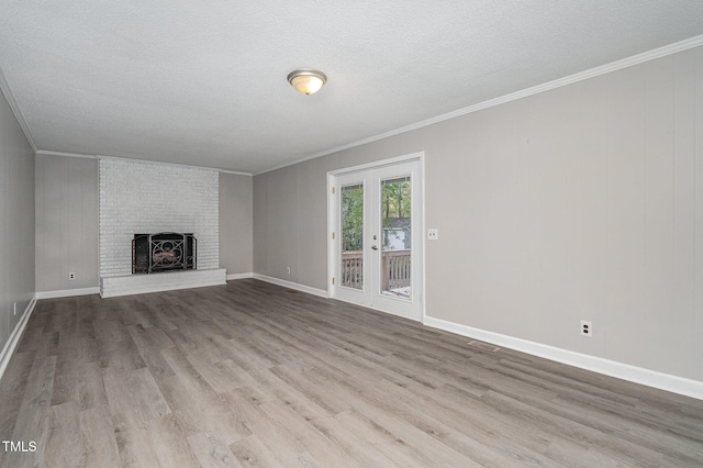 unfurnished living room with a brick fireplace, ornamental molding, and light wood-type flooring