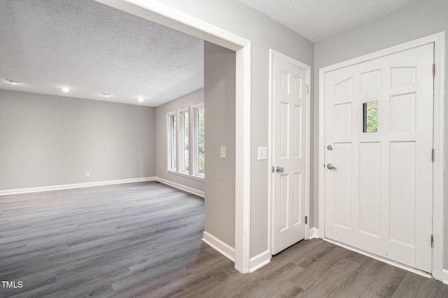 entryway with hardwood / wood-style floors and a textured ceiling