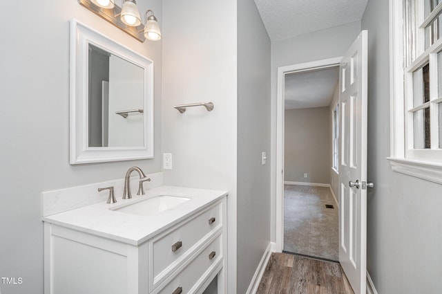 bathroom with vanity, a textured ceiling, and hardwood / wood-style flooring