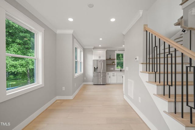 interior space featuring ornamental molding, a healthy amount of sunlight, and hardwood / wood-style floors