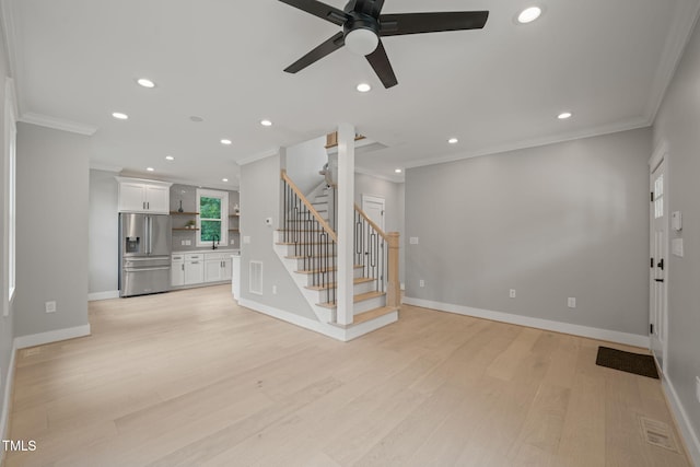 unfurnished living room featuring ceiling fan, light wood-type flooring, and crown molding