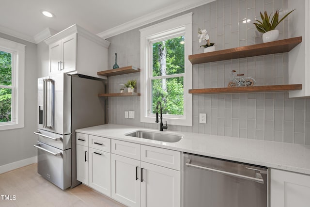 kitchen featuring a healthy amount of sunlight, white cabinetry, sink, and appliances with stainless steel finishes