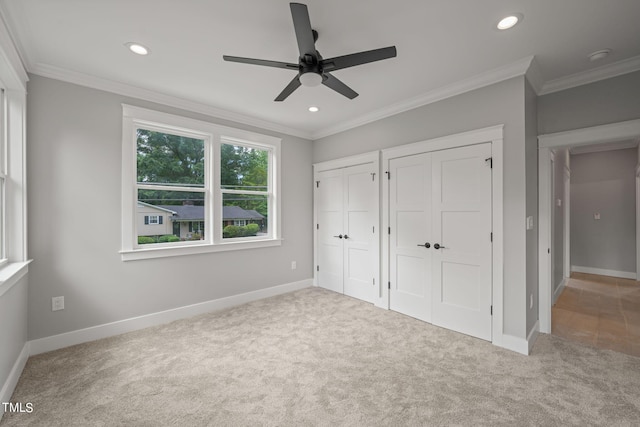 unfurnished bedroom featuring light carpet, ceiling fan, and ornamental molding