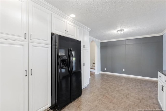 kitchen with black refrigerator with ice dispenser, ornamental molding, white cabinetry, a textured ceiling, and light parquet flooring