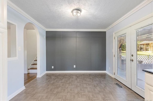 spare room with french doors, crown molding, and light parquet floors