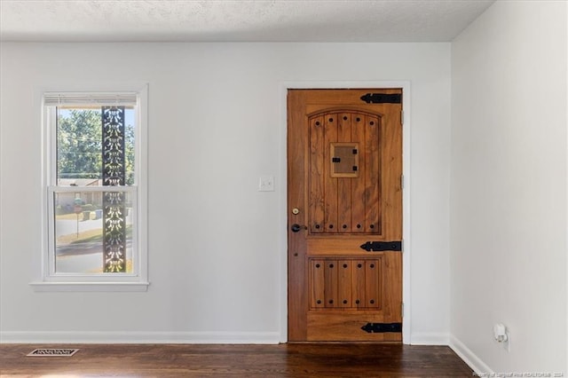 entrance foyer featuring a textured ceiling and dark hardwood / wood-style floors