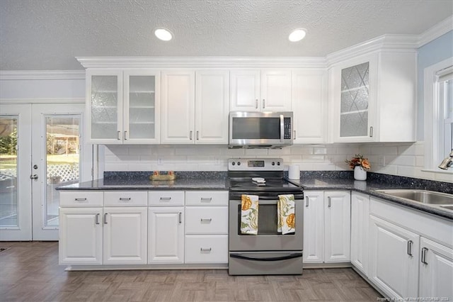 kitchen with ornamental molding, white cabinets, stainless steel appliances, and sink