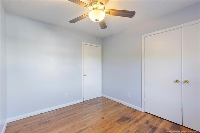 unfurnished bedroom featuring a closet, light hardwood / wood-style floors, and ceiling fan