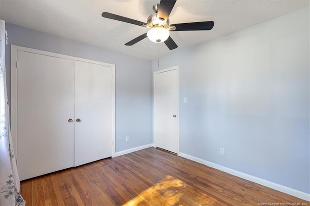 unfurnished bedroom with hardwood / wood-style floors, a closet, and ceiling fan