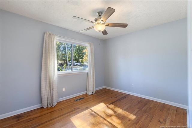 spare room with a textured ceiling, wood-type flooring, and ceiling fan