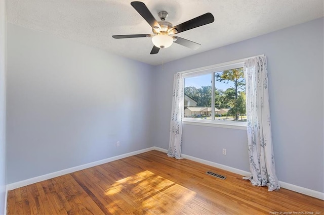 empty room featuring a textured ceiling, hardwood / wood-style flooring, and ceiling fan
