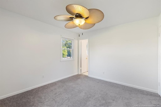 carpeted spare room featuring ceiling fan