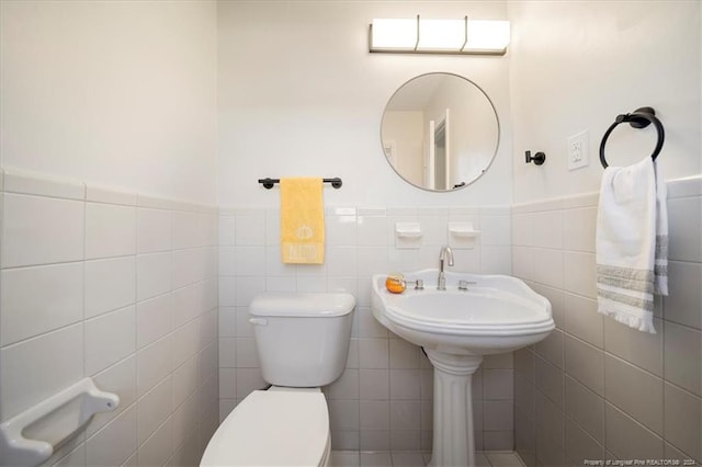 bathroom featuring toilet and tile walls