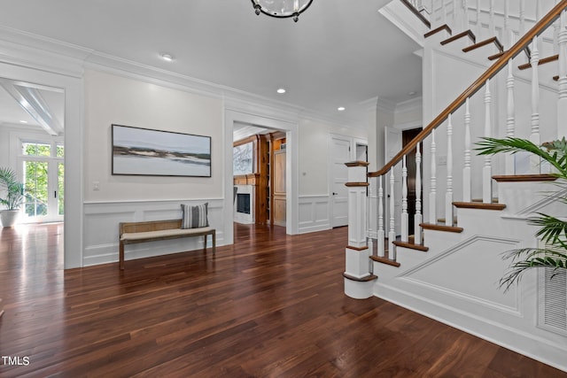 foyer entrance with crown molding and dark hardwood / wood-style floors