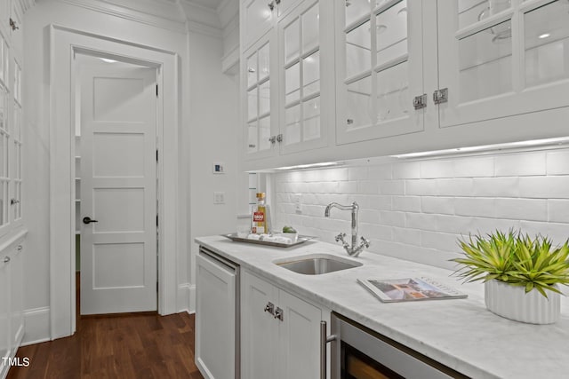 kitchen featuring light stone counters, backsplash, white cabinetry, dark hardwood / wood-style floors, and sink