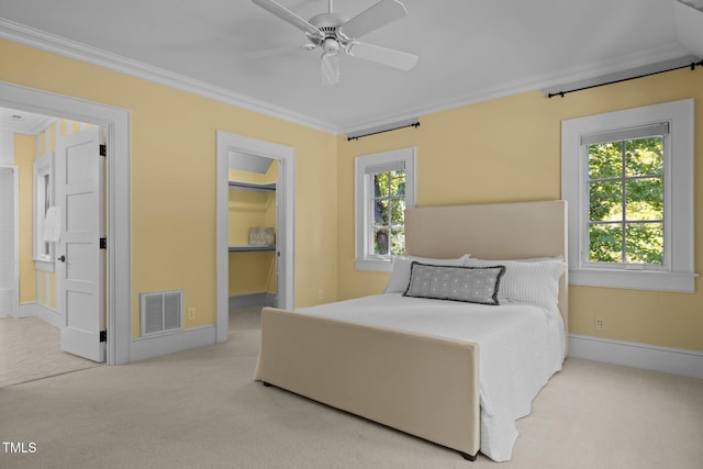 carpeted bedroom featuring multiple windows, ornamental molding, and ceiling fan