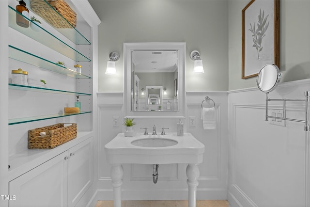 bathroom featuring ornamental molding and sink