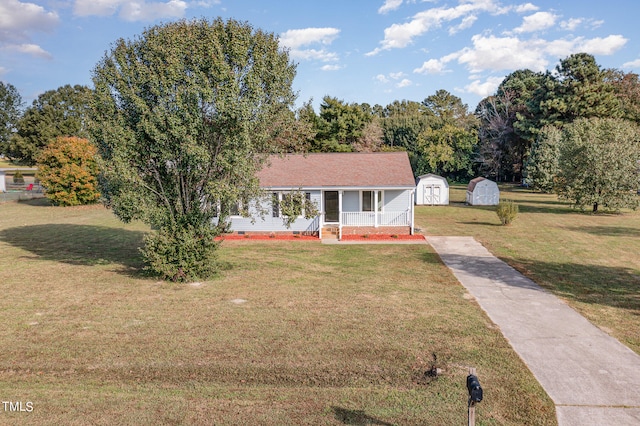 view of front facade featuring a porch, a storage unit, and a front lawn