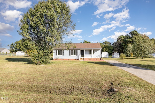 ranch-style home with a storage shed and a front yard