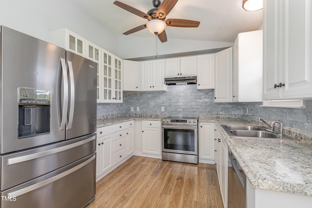 kitchen featuring lofted ceiling, stainless steel appliances, sink, white cabinets, and tasteful backsplash