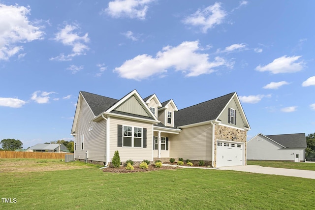 craftsman-style home with concrete driveway, a front yard, board and batten siding, and fence