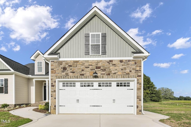 view of front of house featuring concrete driveway, a garage, stone siding, and board and batten siding