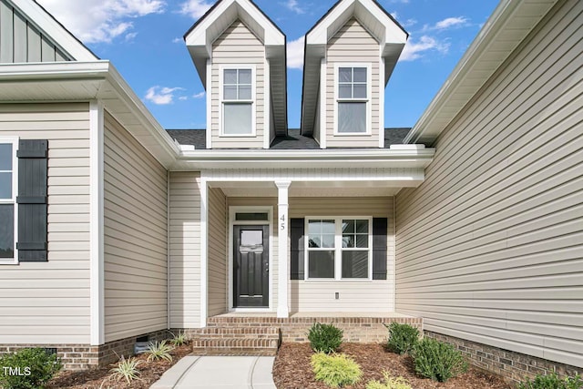 view of exterior entry featuring covered porch