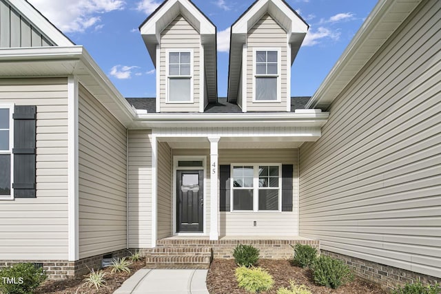 entrance to property featuring a porch and crawl space