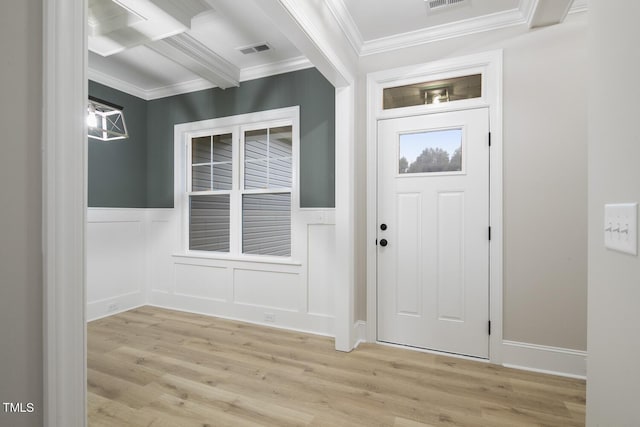 foyer with ornamental molding, light wood-style floors, wainscoting, and visible vents