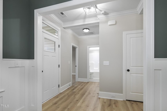 hall featuring crown molding, visible vents, light wood-style flooring, and baseboards