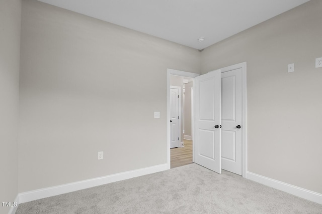 unfurnished bedroom with baseboards and carpet