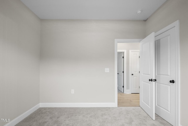 unfurnished bedroom featuring carpet flooring and baseboards