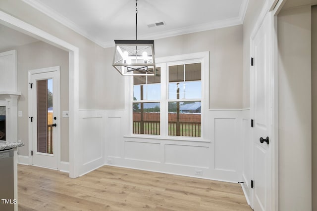 dining area featuring crown molding, light hardwood / wood-style flooring, and an inviting chandelier