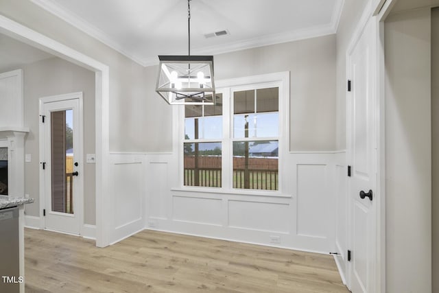 unfurnished dining area with a notable chandelier, a decorative wall, visible vents, and plenty of natural light