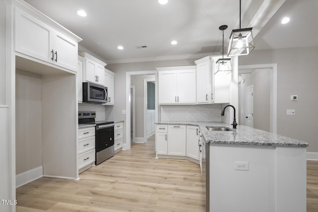kitchen with a peninsula, stainless steel appliances, baseboards, and a sink