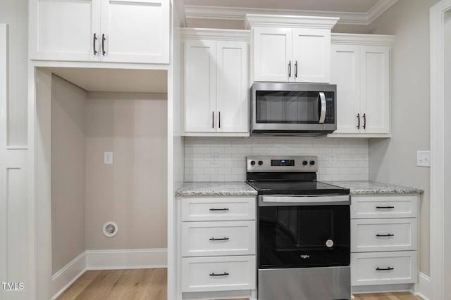 kitchen featuring white cabinetry, light stone countertops, appliances with stainless steel finishes, and backsplash