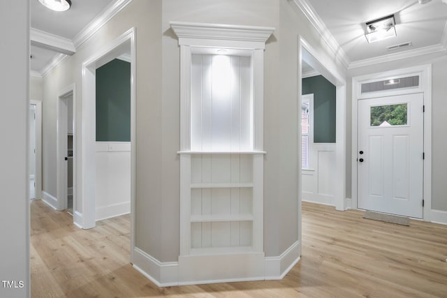 foyer entrance with ornamental molding and light hardwood / wood-style flooring