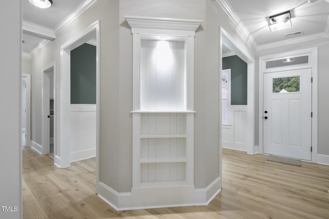 entryway with visible vents, wood finished floors, and ornamental molding