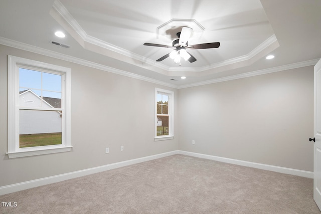 unfurnished room with ornamental molding, a tray ceiling, light colored carpet, and ceiling fan