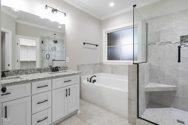 full bathroom with a stall shower, ornamental molding, double vanity, and a sink