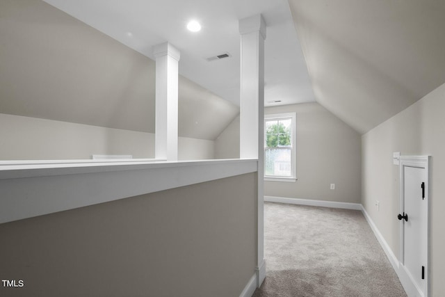 additional living space with vaulted ceiling, carpet flooring, baseboards, and visible vents