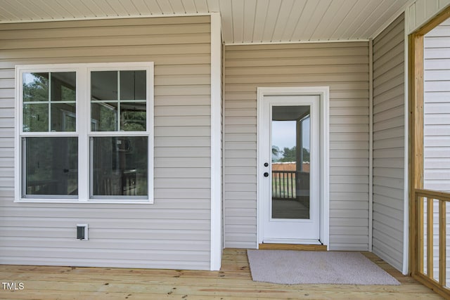 view of exterior entry featuring a wooden deck