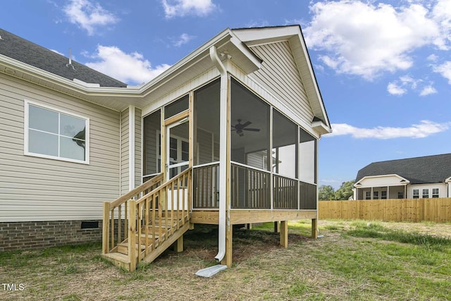 rear view of property with a ceiling fan, a sunroom, crawl space, fence, and stairs