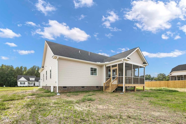 rear view of house with a lawn and a sunroom