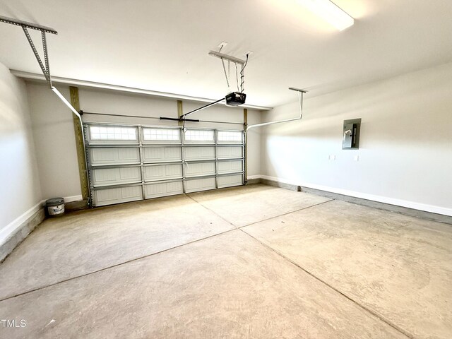 garage with baseboards, a garage door opener, and electric panel