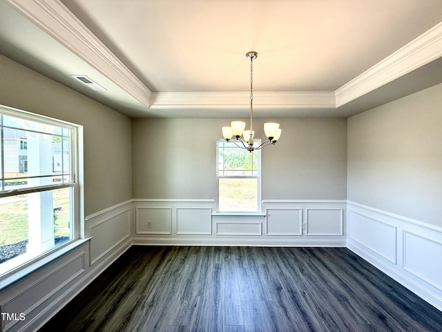 empty room with a raised ceiling, ornamental molding, dark wood-style floors, and visible vents